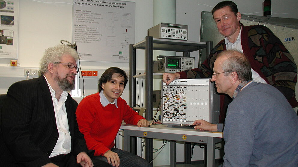 Foto (v. li.): Dipl.-Ing. Werner John (IZM, ASE), M. Sc. Vadim Issakov, Dipl.-Ing. Bernd Bartsch sowie (stehend) Prof. Dr.-Ing. Andreas Thiede (alle ASEC) nutzen auch die wertvolle Messtechnik gemeinsam.