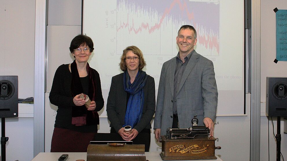 Foto: Auf der Suche nach dem historischen Klang der Stimme: Prof. Dr. Rebecca Grotjahn, Dr. Karin Martensen und Prof. Dr.-Ing. Malte Kob vor einer akustischen Klanganalyse eines Edison-Phonographen. © HfM Detmold/Plettenberg