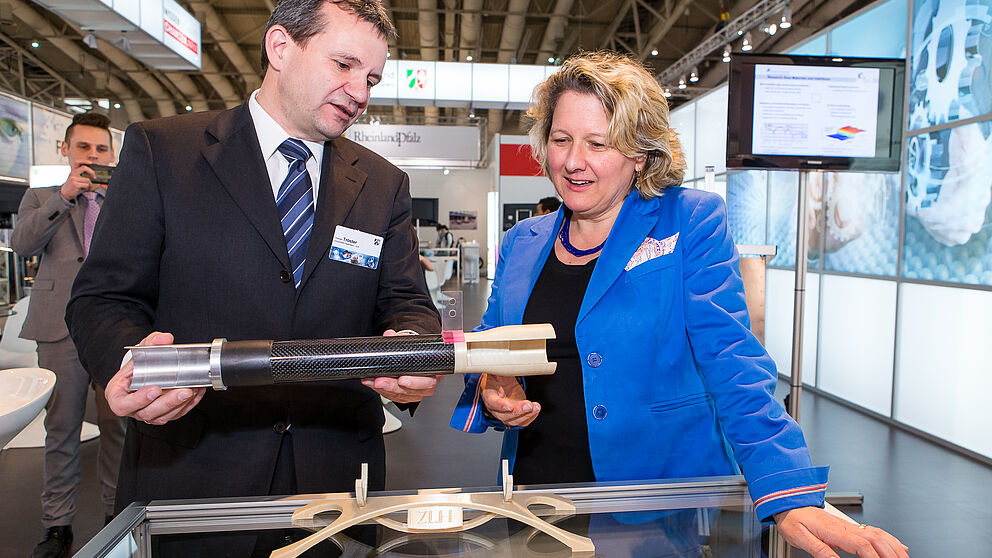 Foto (MIWF NRW): NRW-Wissenschaftsministerin Svenja Schulze im Gespräch mit Prof. Dr. Thomas Tröster, der anhand eines Demonstrators hybride Werkstoffe und Produktionsverfahren erläutert.